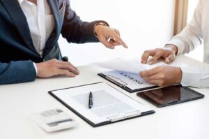 Parents review life insurance papers and household finances at a kitchen table.